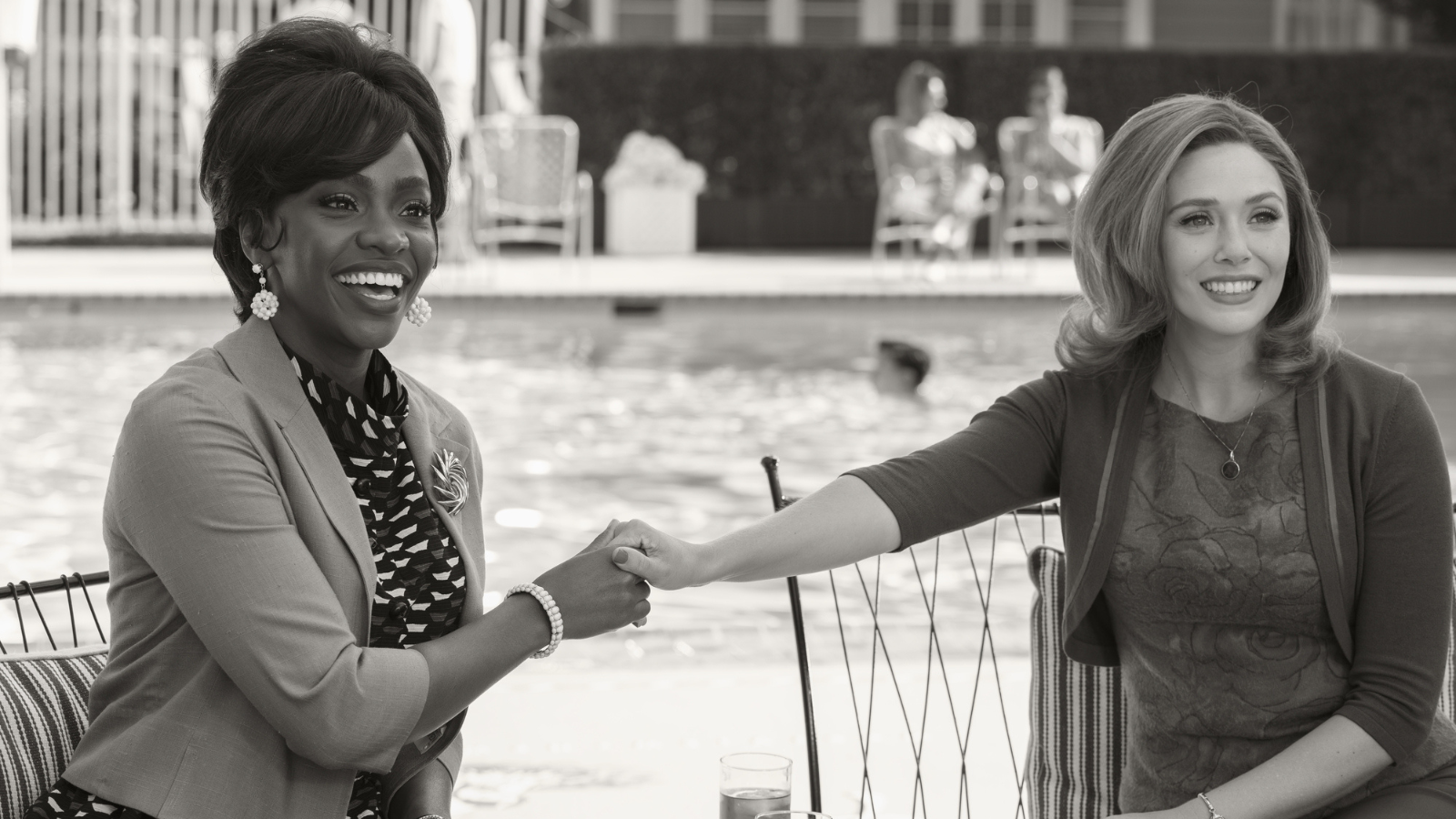 Monica and Wanda wearing light layers while by a pool.