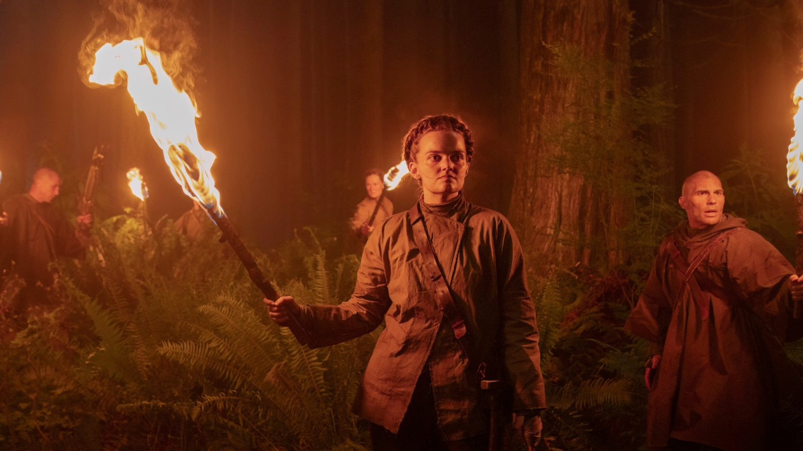 Seraphites in the woods holding torches. They all wear parkas that are hand made.