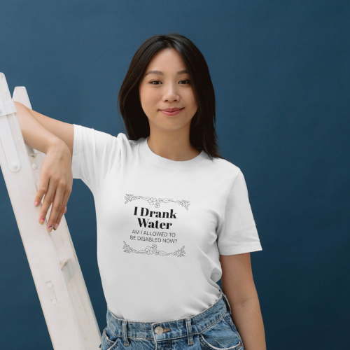 An Asian woman wears a white t-shirt which reads "I drank water, am I allowed to be disabled now?"